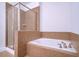 Bathroom with a tiled tub, separate shower, and a soothing neutral color palette at 3202 Saute Way, Avondale Estates, GA 30002
