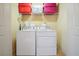 Functional laundry room features a stacked washer and dryer with shelving for storage at 3202 Saute Way, Avondale Estates, GA 30002
