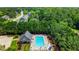 The community pool features lounge chairs and umbrellas surrounded by lush green trees at 733 Exchange Mill Pl, Dacula, GA 30019