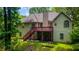 The home's backyard features a deck, stairs, mature trees, and a lush green lawn at 733 Exchange Mill Pl, Dacula, GA 30019