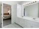 Bathroom featuring dual sinks, white cabinetry, and an open doorway to the bedroom at 733 Exchange Mill Pl, Dacula, GA 30019