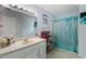 Light-filled bathroom with large vanity and a shower with an eye-catching teal curtain at 733 Exchange Mill Pl, Dacula, GA 30019