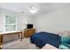 Carpeted bedroom with a ceiling fan, a window, and a wood dresser and desk at 733 Exchange Mill Pl, Dacula, GA 30019