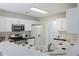 Bright kitchen with white cabinets, black countertops, and stainless steel appliances at 733 Exchange Mill Pl, Dacula, GA 30019
