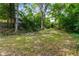 Lush backyard with mature trees and expansive lawn with brick house at 1200 Mansfield Ne Ave, Atlanta, GA 30307
