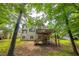 Spacious backyard with a wooden deck, stairs, and lush greenery surrounding the house at 1625 Hawkins Cove Trl, Roswell, GA 30076