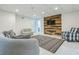 Finished basement with modern decor, wood accent wall, and ample seating at 1625 Hawkins Cove Trl, Roswell, GA 30076