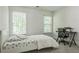 Well-lit bedroom with two windows, neutral walls, and a desk setup at 1625 Hawkins Cove Trl, Roswell, GA 30076