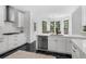 Modern kitchen featuring white cabinets, black marble floors, stainless steel appliances, and a breakfast area at 1625 Hawkins Cove Trl, Roswell, GA 30076