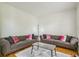 Comfortable living room with hardwood floors, two sofas, a marble coffee table, and a stylish floor lamp at 1625 Hawkins Cove Trl, Roswell, GA 30076