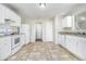 Well-lit kitchen featuring white cabinets, appliances, and neutral countertops at 6595 Browns Mill Ferry Dr, Lithonia, GA 30038