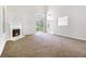 Bright living room featuring a fireplace, sliding glass doors, and plush carpet at 6595 Browns Mill Ferry Dr, Lithonia, GA 30038