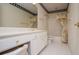 A bathroom with a framed mirror, white vanity and storage, plus shower-tub with floral curtain at 7392 N Mitchell N Ct, Villa Rica, GA 30180