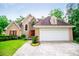 Charming two-story home with stone accents, red door, and well-manicured lawn at 7392 N Mitchell N Ct, Villa Rica, GA 30180