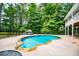 Backyard pool with stone border, steel ladders, patio area, and a lounge bed with mature trees in background at 7392 N Mitchell N Ct, Villa Rica, GA 30180