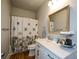 Bathroom with decorative shower curtain, modern vanity, and natural-toned walls at 302 Aspen Valley Ln, Dallas, GA 30157