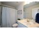 White bathroom vanity with a patterned shower curtain and modern fixtures at 302 Aspen Valley Ln, Dallas, GA 30157