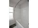 Clean bathroom featuring a white bathtub with shower, vinyl flooring, and a window at 302 Aspen Valley Ln, Dallas, GA 30157
