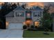 Attractive two-story home with landscaped front yard and a spacious driveway at dusk at 302 Aspen Valley Ln, Dallas, GA 30157