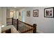 Upstairs hallway featuring wooden railings, neutral walls, and decorative Gathering photos at 302 Aspen Valley Ln, Dallas, GA 30157