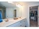 Bright main bathroom boasts double sinks with white cabinets, large mirror and a door to the walk-in closet at 302 Aspen Valley Ln, Dallas, GA 30157