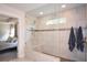 Spa-like main bathroom featuring tiled shower with glass enclosure and built in bench, tiled floors, and neutral decor at 302 Aspen Valley Ln, Dallas, GA 30157