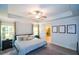 Light-filled main bedroom features a ceiling fan, neutral decor, tray ceiling, and ensuite bath at 302 Aspen Valley Ln, Dallas, GA 30157