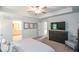 Main bedroom featuring a neutral decor, ensuite bath, tray ceiling, ceiling fan, and a dresser with mounted television at 302 Aspen Valley Ln, Dallas, GA 30157