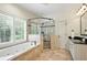 Bright bathroom featuring a large bathtub, walk-in shower, window with shutters, and modern fixtures at 400 Mabry Pl, Atlanta, GA 30319