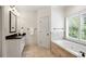 Clean and stylish bathroom with a white vanity, soaking tub, plantation shutters, and granite counter at 400 Mabry Pl, Atlanta, GA 30319