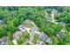 Aerial view of lush community featuring tree-lined streets, manicured lawns, and multiple homes with large wooded lots at 6017 Chestatee Creek Nw Ct, Acworth, GA 30101