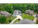 Aerial shot of an immaculate white house, circular driveway, and lush green yard, nestled among mature trees at 6017 Chestatee Creek Nw Ct, Acworth, GA 30101