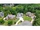 Aerial view of a pristine white house with dark roof, surrounded by beautiful mature trees and manicured lawns at 6017 Chestatee Creek Nw Ct, Acworth, GA 30101