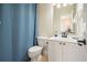 Well-lit bathroom with a sink vanity, toilet, and a stylish blue shower curtain at 6017 Chestatee Creek Nw Ct, Acworth, GA 30101