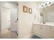 Clean bathroom with a white vanity, decorative mirror, and a tiled floor at 6017 Chestatee Creek Nw Ct, Acworth, GA 30101