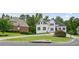 Elegant white house featuring black shutters, a manicured lawn, and an expansive driveway in a lush, green setting at 6017 Chestatee Creek Nw Ct, Acworth, GA 30101