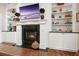 Beautiful fireplace framed by built-in shelves with a large television above the mantle at 6017 Chestatee Creek Nw Ct, Acworth, GA 30101