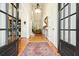 Elegant foyer showcasing hardwood floors, a grand chandelier, and views into the adjacent living spaces through glass doors at 6017 Chestatee Creek Nw Ct, Acworth, GA 30101