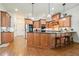 Well-lit kitchen with wood cabinets, granite countertops, stainless steel appliances, and a breakfast bar at 6017 Chestatee Creek Nw Ct, Acworth, GA 30101