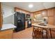 Kitchen with wood cabinets, black appliances, tile backsplash, a corner sink, and an eat-in breakfast table at 6017 Chestatee Creek Nw Ct, Acworth, GA 30101