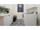 A tidy laundry room features white cabinets, black-and-white patterned flooring, and modern appliances at 6017 Chestatee Creek Nw Ct, Acworth, GA 30101
