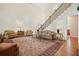 Expansive living room with open staircase, seating, hardwood floors, and lots of natural light at 6017 Chestatee Creek Nw Ct, Acworth, GA 30101