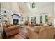 Cozy living room with high ceilings, a fireplace, built-in shelving, and plenty of natural light at 6017 Chestatee Creek Nw Ct, Acworth, GA 30101