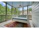 Inviting screened-in porch with a swing and a scenic view of the trees at 6017 Chestatee Creek Nw Ct, Acworth, GA 30101