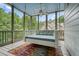 Inviting screened porch with a comfortable swing bed, ideal for relaxation and enjoying the outdoors at 6017 Chestatee Creek Nw Ct, Acworth, GA 30101