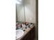 Bathroom featuring a vanity sink with toiletries, mirror, and dark wood cabinets at 80 Place Fontaine, Lithonia, GA 30038