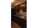 Well-equipped kitchen featuring dark wood cabinets, granite countertops, and modern appliances at 80 Place Fontaine, Lithonia, GA 30038