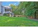 A lush green backyard has mature trees, a small fence, and stairs to the deck at 1875 Edgemont Ct, Cumming, GA 30041
