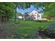 A lush green backyard has mature trees, a creek, and steps to a deck at 1875 Edgemont Ct, Cumming, GA 30041