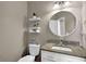 Charming half bath with a round mirror and floating shelves for storage at 1875 Edgemont Ct, Cumming, GA 30041